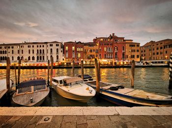 Boats moored in canal against buildings in city