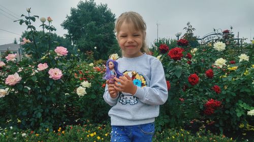 Full length of girl holding flowering plants