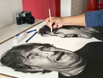 High angle view of man holding sunglasses on table