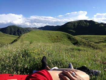 Low section of man on field against mountains