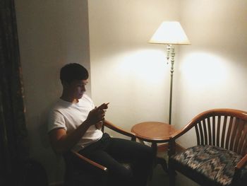 Young man sitting on chair at home