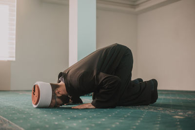 Side view of young man sleeping on floor