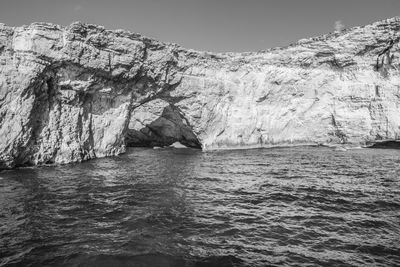 Rock formations by sea against sky