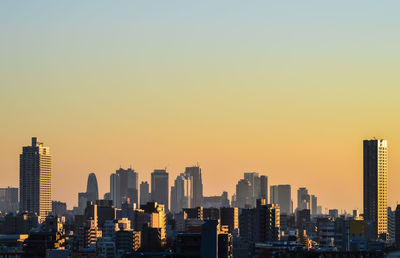 Mid distance view of city against sky during sunset