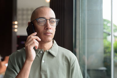 Portrait of young man wearing sunglasses standing in office