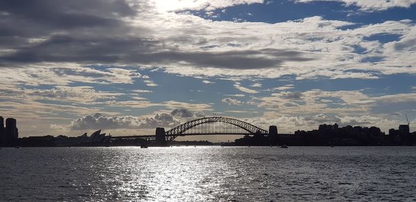 Bridge over river against cloudy sky