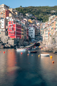 Sailboats in sea by buildings in city