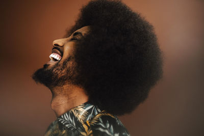 Cheerful young man laughing in studio