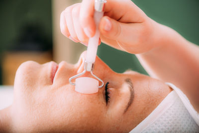 Guasha face massage in beauty salon, massage technique for stimulating pressure points on the face