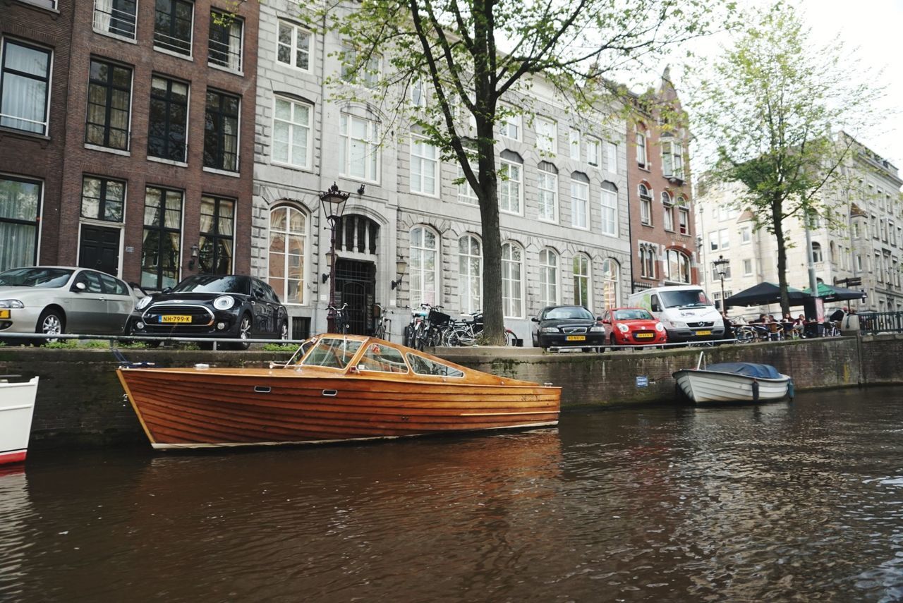 transportation, mode of transport, nautical vessel, water, architecture, river, building exterior, moored, built structure, waterfront, tree, car, travel destinations, outdoors, day, city, no people, rowboat, nature, sky