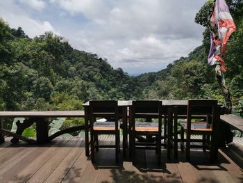 Empty chairs and tables against sky