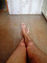 Low section of woman relaxing on tiled floor