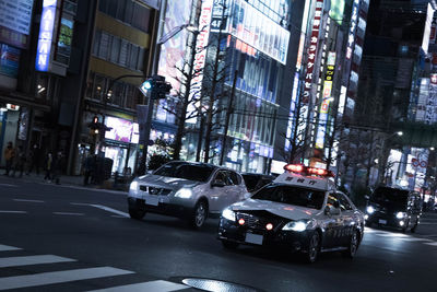 Cars on road amidst buildings in city at night