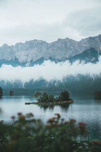 Scenic view of lake by mountains against sky