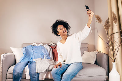 Portrait of smiling woman sitting on sofa at home