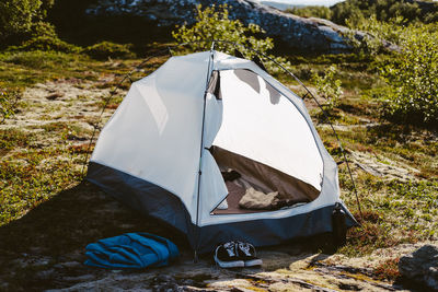 Camping tent and shoes set in a sunny camp site