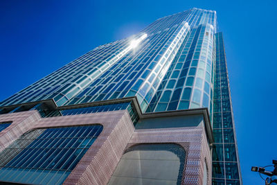 Low angle view of modern building against clear blue sky