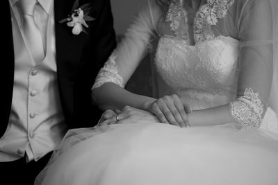 Midsection of bride and groom