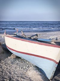 Boats moored on beach against sky