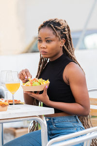 Young woman eating food at restaurant