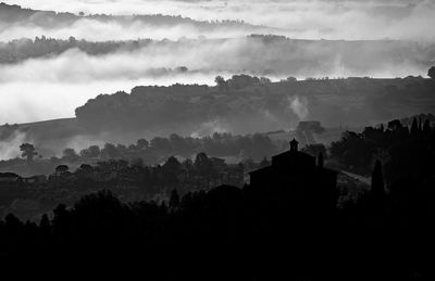 Silhouette trees on landscape against sky
