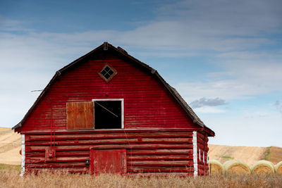 Barn on field against sky