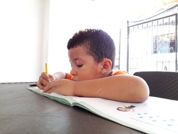 Portrait of boy making face on table