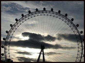 Silhouette ferris wheel against sky