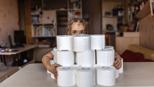 Close-up of smiling girl with toilet paper on table