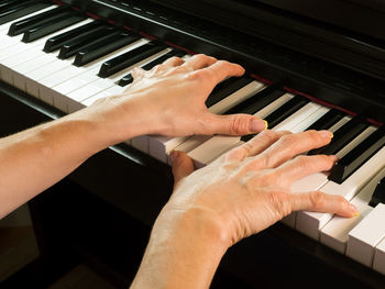 Cropped image of hands playing piano