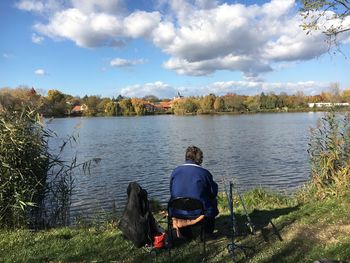 Rear view of man overlooking lake
