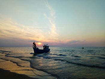 Boat on sea against sky during sunset