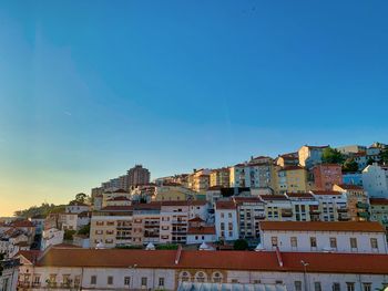 Houses in town against clear blue sky