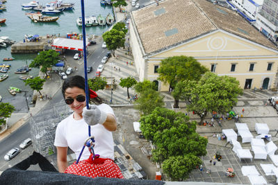 Caucasian woman wearing hero costume descending a tall building in rappel. salvador bahia brazil.