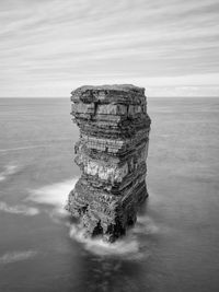 Rock formation on sea against sky