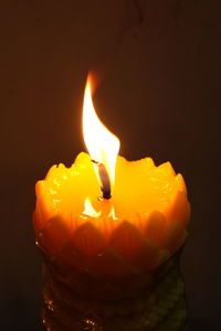 Close-up of lit candle against black background