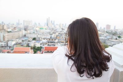 Rear view of woman looking at cityscape