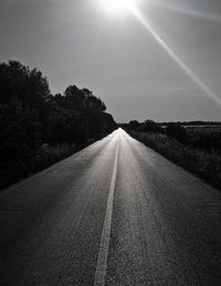 Road amidst trees against sky