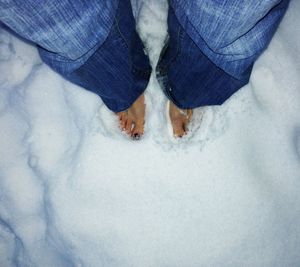 Low section of people standing on snow covered landscape