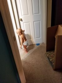 Full length of baby standing by door at home