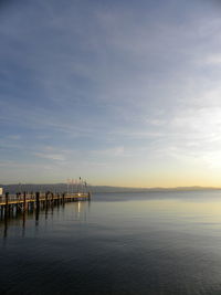 Pier on sea against sky during sunset