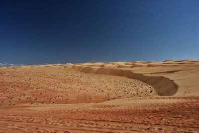 Scenic view of desert against clear blue sky