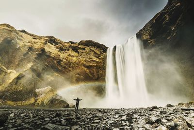 Rear view of man against waterfall