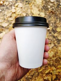 Close-up of hand holding coffee cup