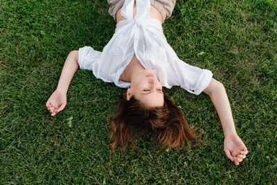High angle view of woman lying on grass