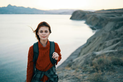 Portrait of smiling young woman standing in sea