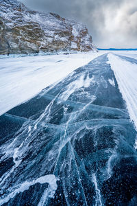 Turquoise ice ii lake baikal - siberia ice surface with deep cracks on lake baikal, russia