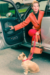 Woman with dog sitting in car