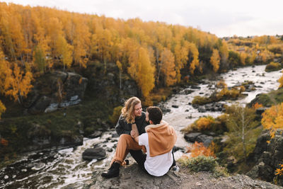 Happy people in love are travel hike in nature in the autumn forest. romantic trip to countryside