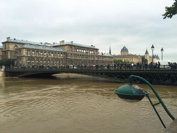 Bridge over river against buildings